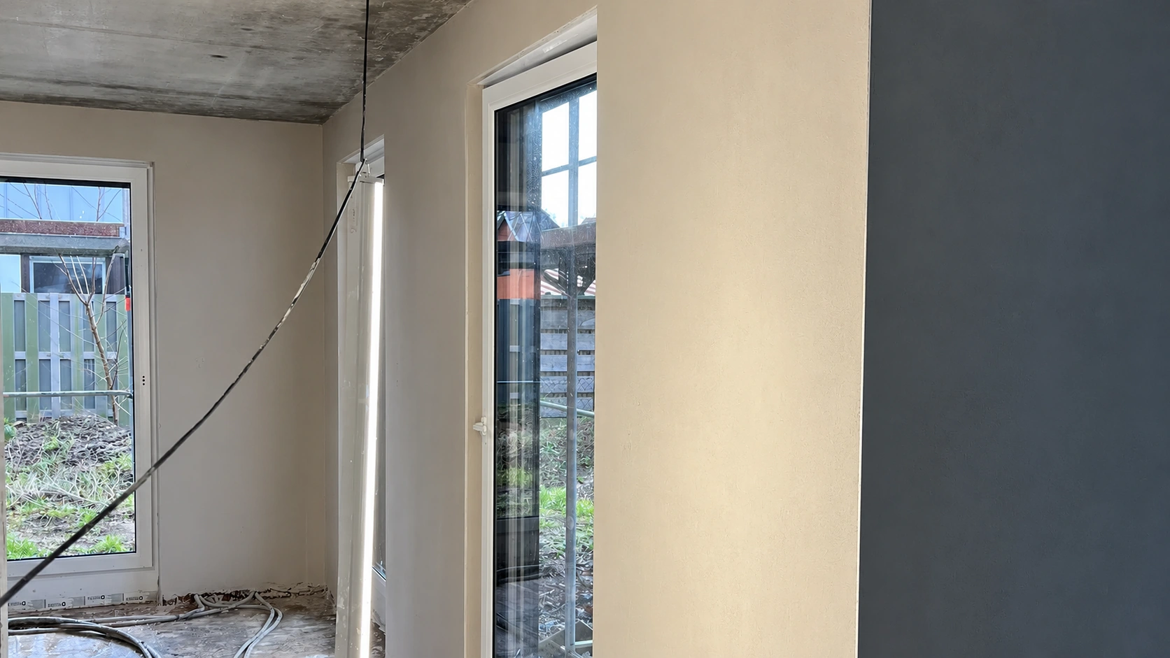 Frisch verputzter Innenraum mit bodentiefen Fenstern